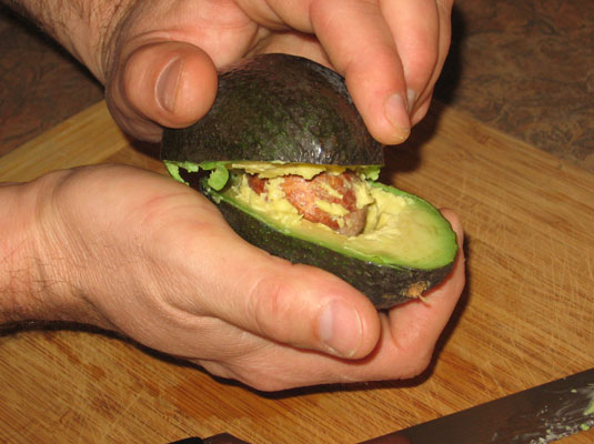 Eine Avocado entkernen und schälen