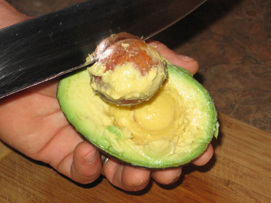 Eine Avocado entkernen und schälen