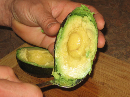 Eine Avocado entkernen und schälen